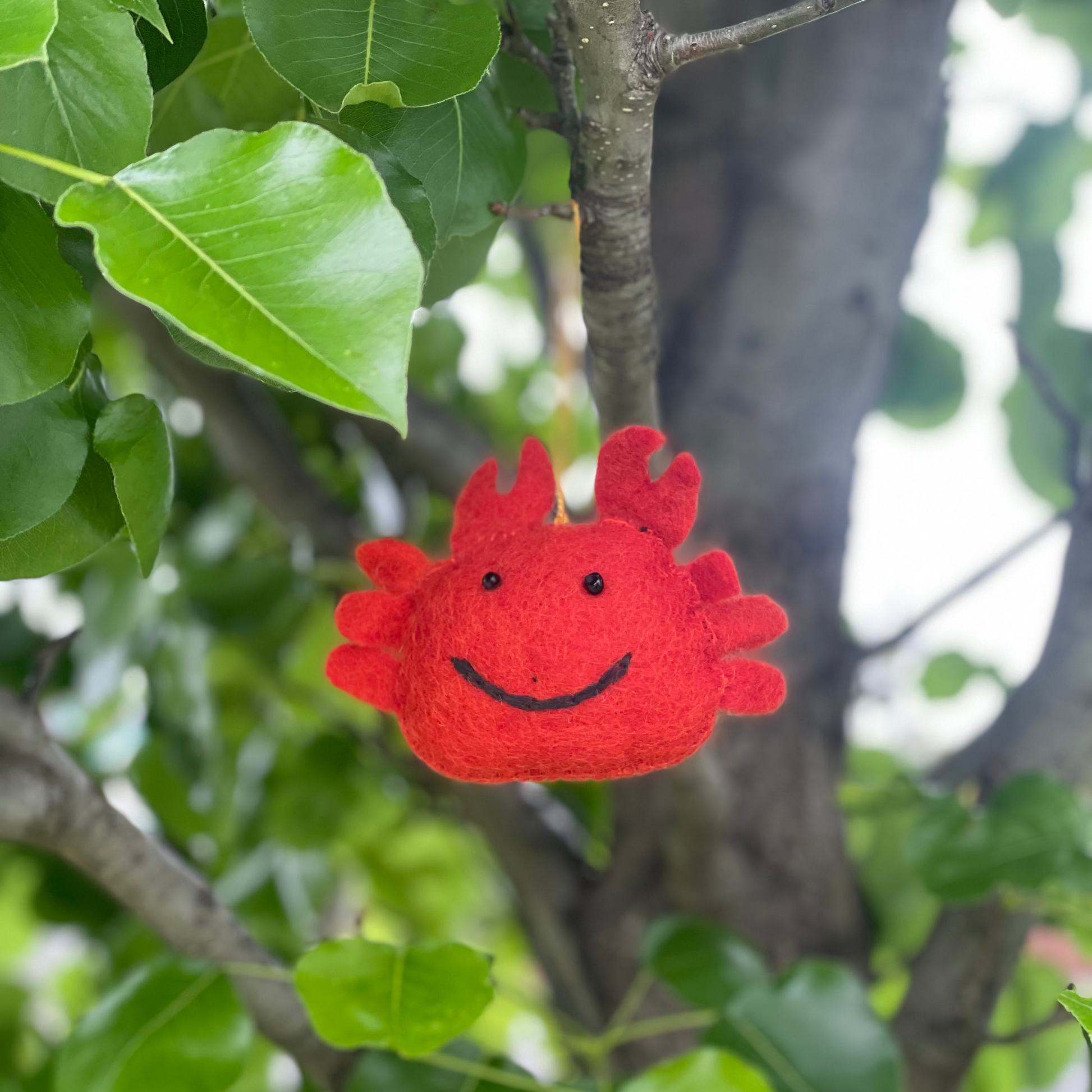 Red felt crab ornament with a smiling face 